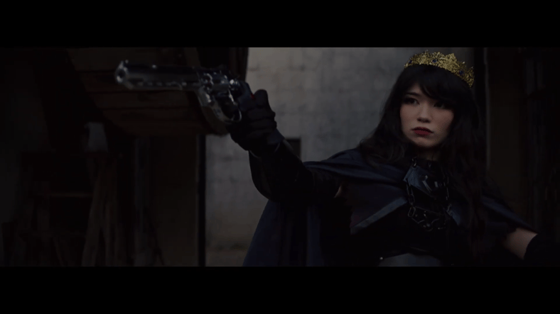 Emiru draws a gun while dressed as a queen promoting OTK via YouTube