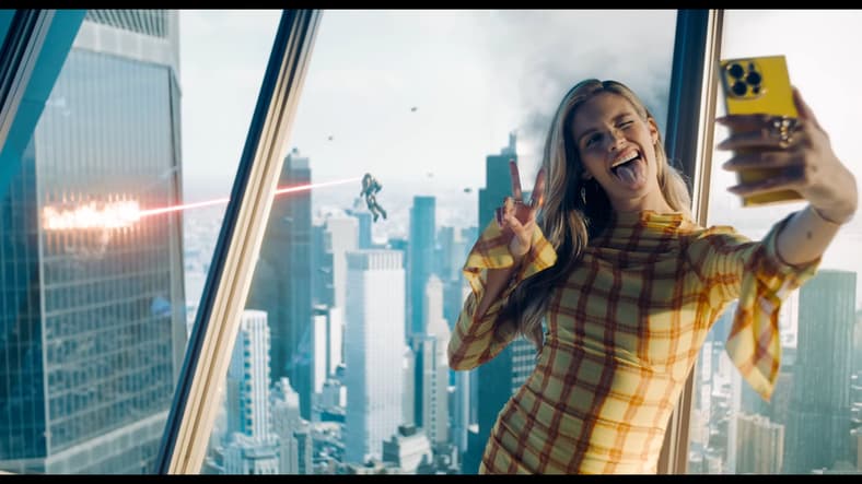 Eve Teschmacher (Sara Sampaio) snaps a selfie amidst the Man of Steeel's (David Corenswet) battle with the Hammer of Boravia (TBA) in Superman (2025), DC Studios
