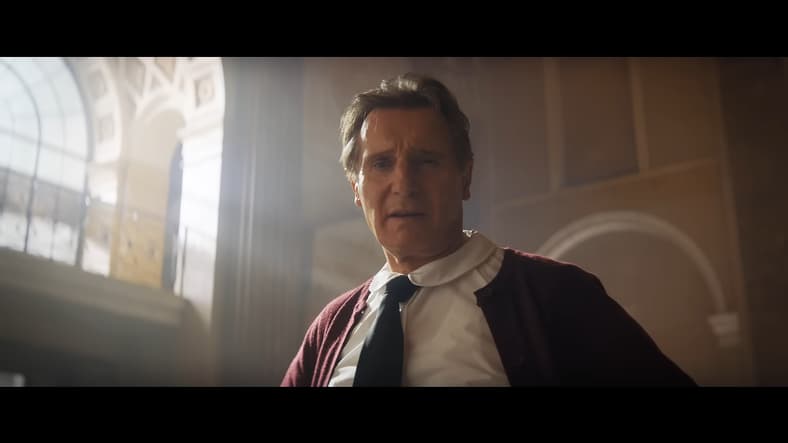 Frank Drebin Jr. (Liam Neeson) introduces himself to a group of hostages in The Naked Gun (2025), Paramount Pictures