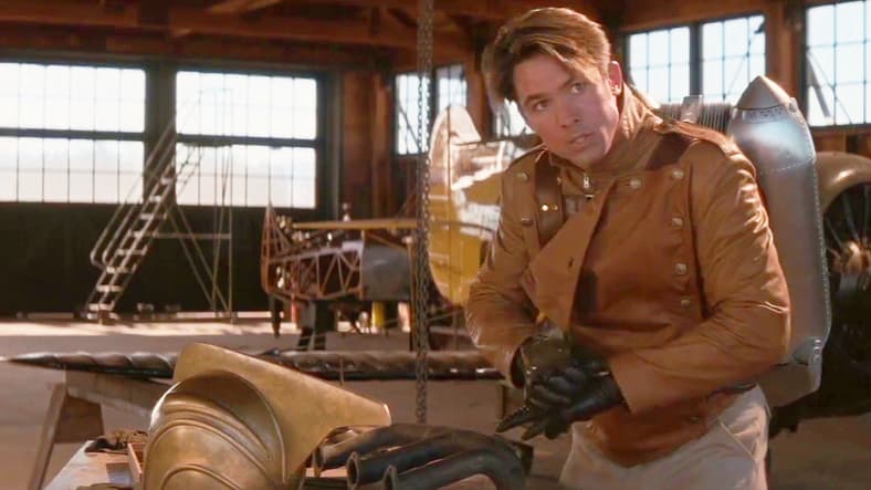 Cliff (Billy Campbell) suits up to save Malcom (Eddie Jones) from a potential plane crash in The Rocketeer (1991), Walt Disney Pictures