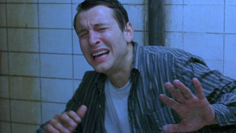 Adam (Leigh Whannell) awakens as a capture of Jigsaw in Saw (2004), Lionsgate Films