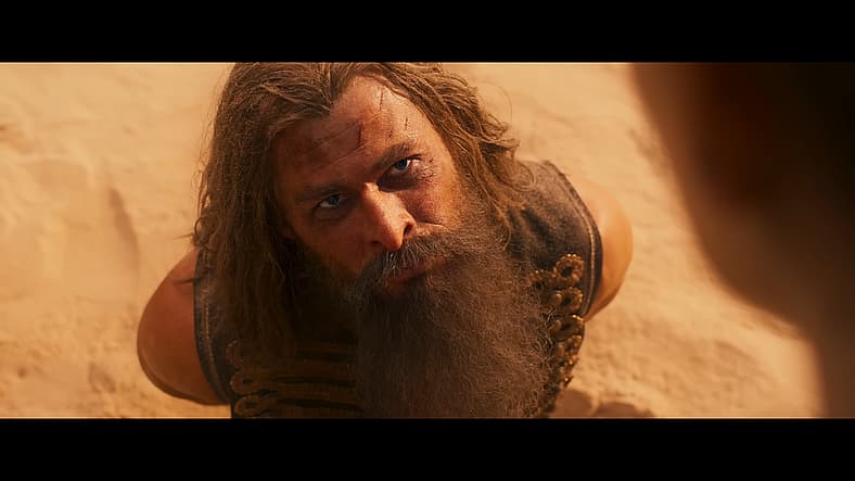 Warlord Dementus (Chris Hemsworth) at mercy of Furiosa (Anya Taylor-Joy) in Furiosa: A Mad Max Saga