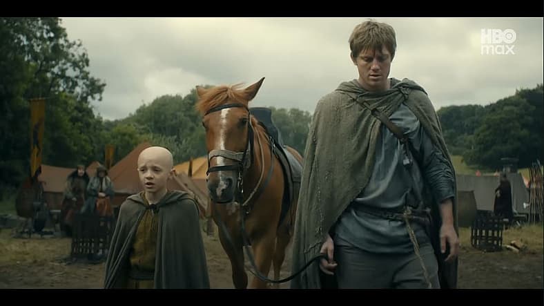 Egg (Dexter Sol Ansell) and Dunk (Peter Claffey) walking through Ashford Meadow in A Knight of the