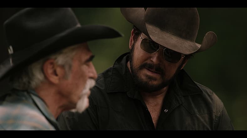 Rip Wheeler (Cole Hauser) speaks with Lloyd (Forrie J. Smith) at John Dutton's grave in Yellowstone