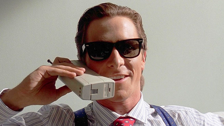 Patrick Bateman (Christian Bale) makes dinner reservations in American Psycho (2000), Lionsgate Films