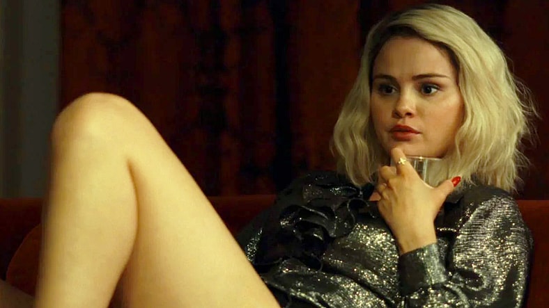 Jessi (Selena Gomez) tells Emilia (Karla Sofía Gascón) about her plans to marry Gustavo (Édgar Ramírez) in Emilia Pérez (2024), Netflix