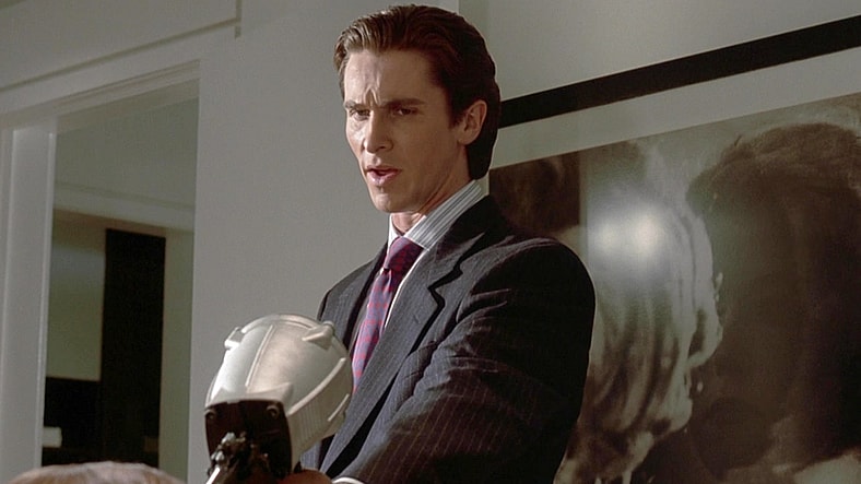 Patrick Bateman (Christian Bale) dances with the idea of pulling the trigger on Jean (Chloë Sevigny) in American Psycho (2000), Lionsgate Films