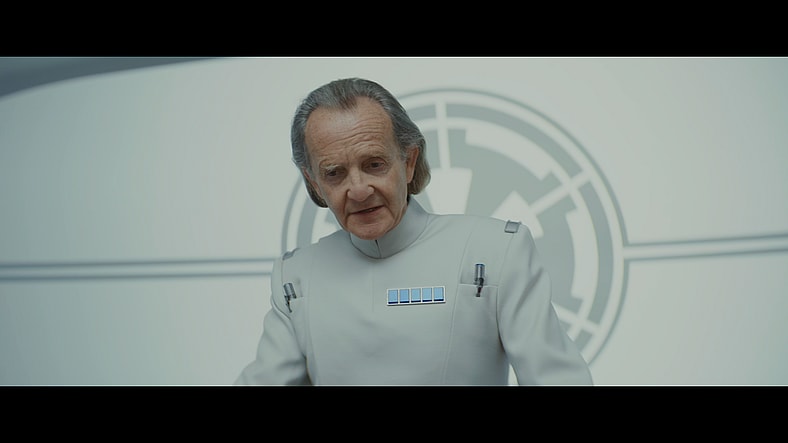 Major Partagaz (Anton Lesser) attempts to dissuade Dedrao (Denise Gough) of her fears regarding the Imperials' bombing plans in Andor Season 2 Episode 8 "Who Are You?" (2025), Lucasfilm