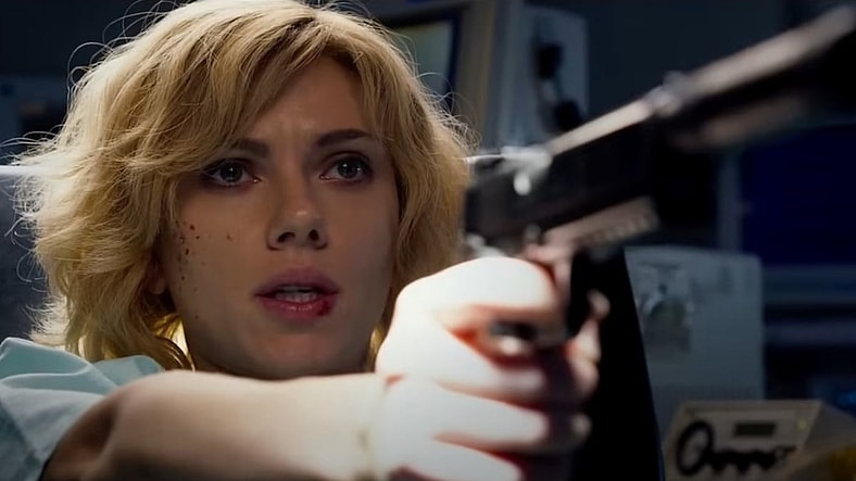 Lucy (Scarlett Johansson) pulling a gun on the doctors in Lucy 2014, Universal Pictures