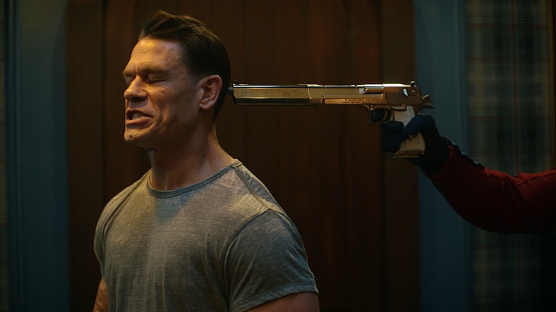 Peacemaker (John Cena) attempts to stammer out an apology for breaking and entering in Peacemaker Season 2 Episode 1 "The Ties That Grind" (2025), DC Studios