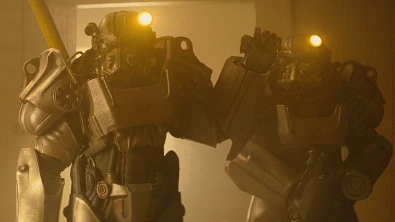 Xander (Kumail Nanjiani) and Maximus (Aaron Moten) gather recon on the Sunset Sarsaparilla factory in Fallout Season 2 Episode 3 "The Prolifigate" (2026), Amazon