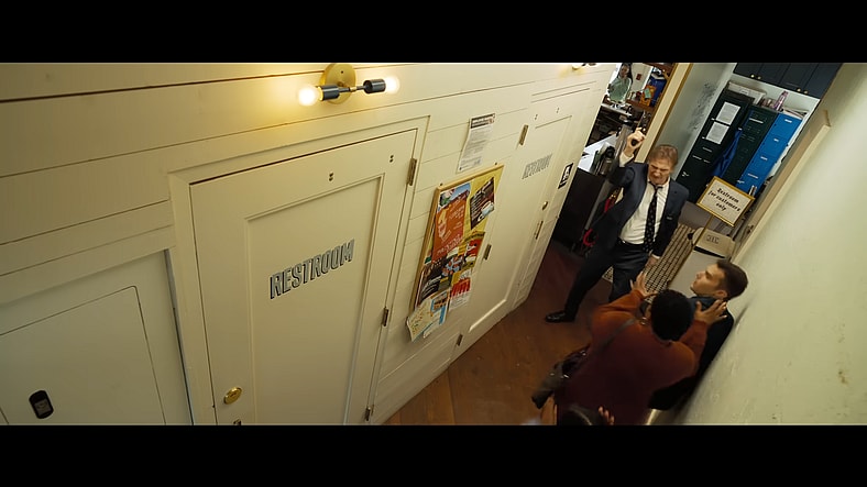 Frank Drebin Jr. (Liam Neeson) requests to use the restroom in The Naked Gun (2025), Paramount Pictures