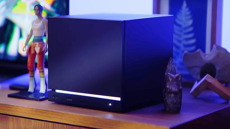 A figure of Portal protagonist Chell rests next to the titular hardware in Steam Hardware Announcement in the Steam Machine Hardware Announcement Trailer (2026), Valve