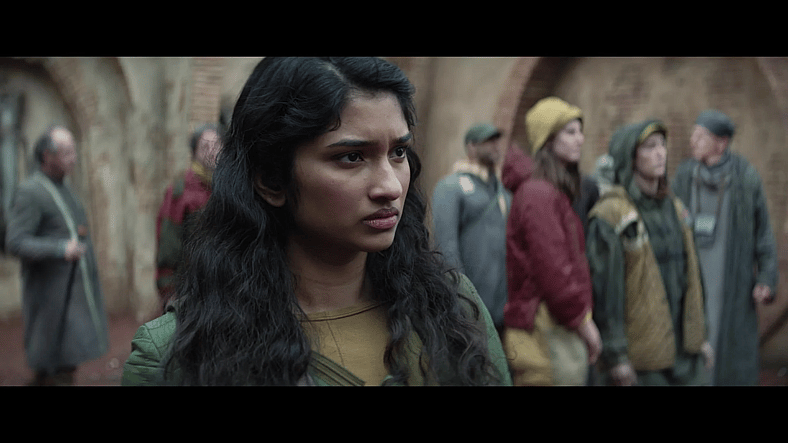 Cinta (Varada Sethu) observes Maarva's  (Fiona Shaw) funeral on Ferrix in Andor Season 1 Episode 12 "Rix Road" (2022), Lucasfilm