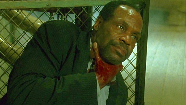 Detective Tapp (Danny Glover) bleeds out after being shot by Zep (Michael Emerson) in Saw (2004), Lionsgate Films