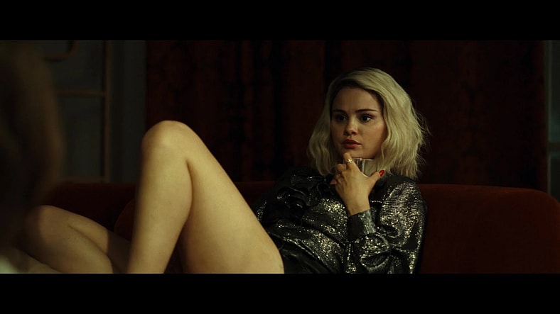 Jessi (Selena Gomez) tells Emilia (Karla Sofía Gascón) about her plans to marry Gustavo (Édgar Ramírez) in Emilia Pérez (2024), Netflix