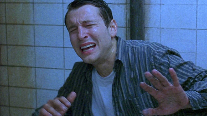 Adam (Leigh Whannell) awakens as a capture of Jigsaw in Saw (2004), Lionsgate Films