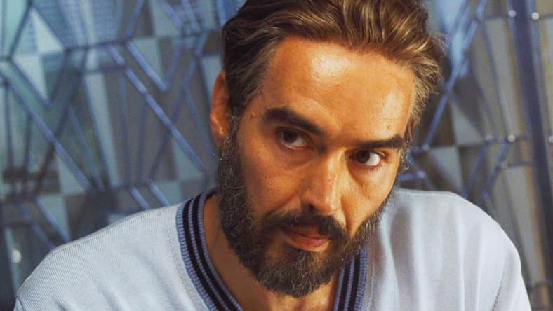Dr. Windlesham (Russell Brand) is asked some questions by Inspector Poirot (Kenneth Branagh) in Death on the Nile (2022), 20th Century Studios