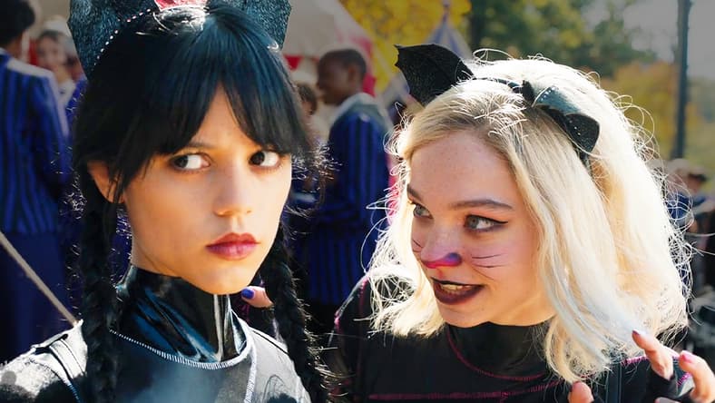 Wednesday (Jenna Ortega) and Enid (Emma Myers) emerge from the canoe race victorious in Wednesday Season 1 Episode 2 "Woe Is The Loneliest Number" (2022), Netflix