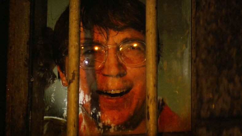 An incarcerated Riddler (Paul Dano) meets Batman (Robert Pattinson) for the first time in The Batman (2022) via Warner Bros. Pictures