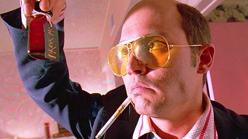 Raoul Duke (Johnny Depp) retrieves a vial of adrenochrome from Dr. Gonzo's (Benicio Del Toro) bag in Fear and Loathing in Las Vegas (1998), Universal Pictures