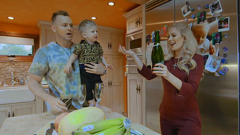 Spencer Pratt, carrying his son Gunner while his wife Heldi Montag opens a wine bottle in The Hills: New Beginnings Season 1, 2019, MTV
