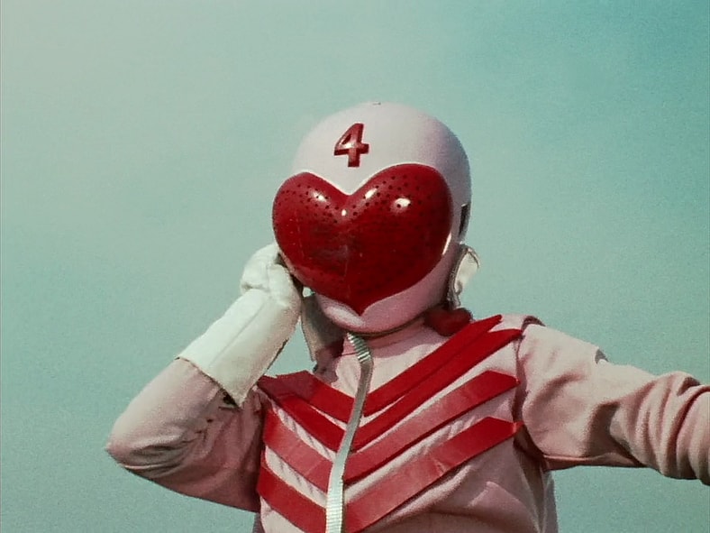 Peggy (Lisa Komaki) prepares to test her new Momorenger powers against the Black Cross Army in Himitsu Sentai Gorenger Episode 1 "The Crimson Sun! The Invincible Gorengers" (1975), Toei Co. Ltd.