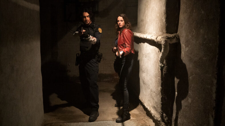 Leon Kennedy (Avan Jogia) and Claire Redfield (Kaya Scodelario) armed and ready in in Resident Evil: Welcome to Raccoon City (2021), Sony Pictures Entertainment