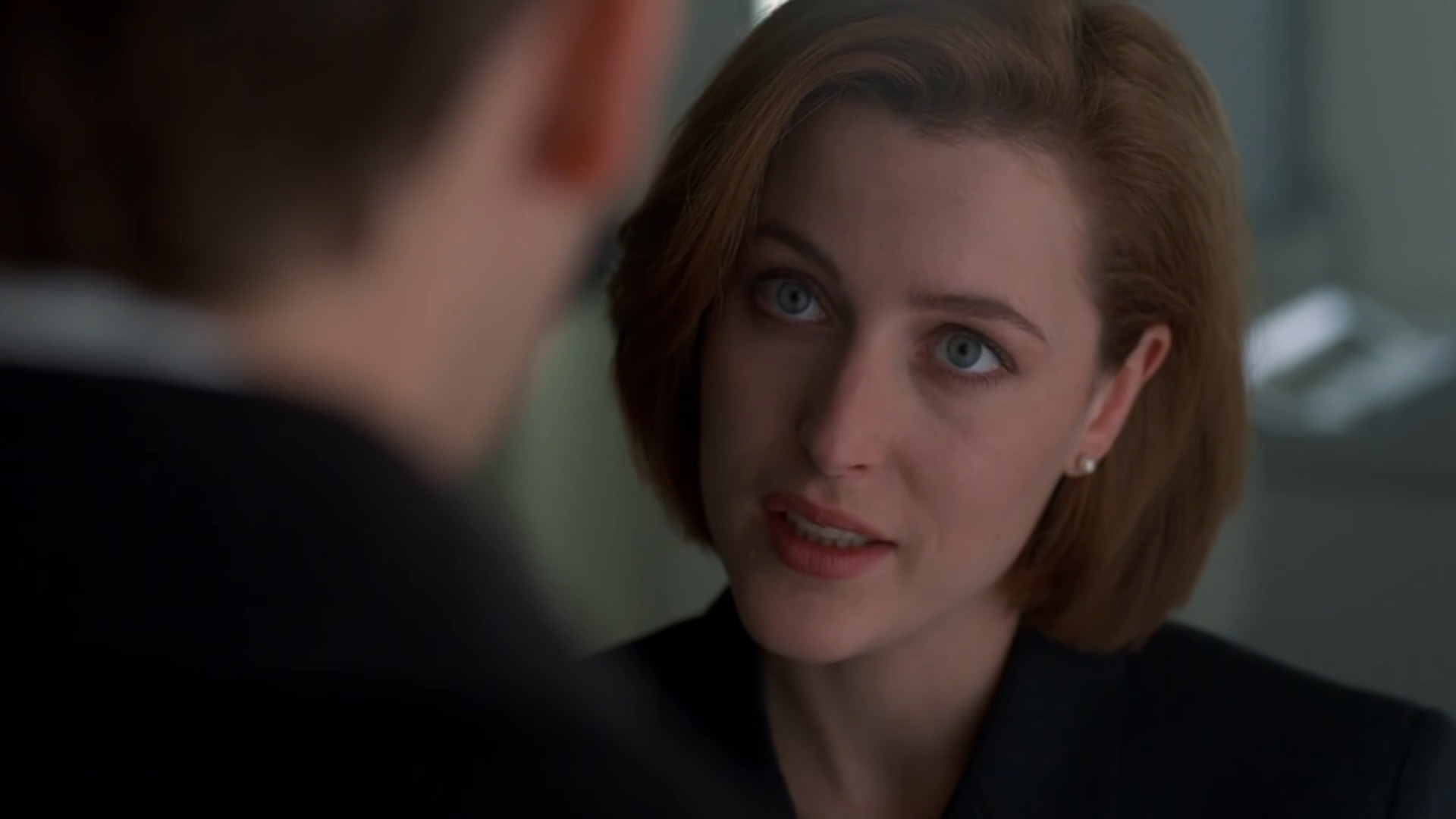 Agent Scully (Gillian Anderson) tries to get through to Agent Mulder (David Duchovny) in The X-Files Season 4 Episode 14 "Memento Mori" (1997), 20th Century Studios