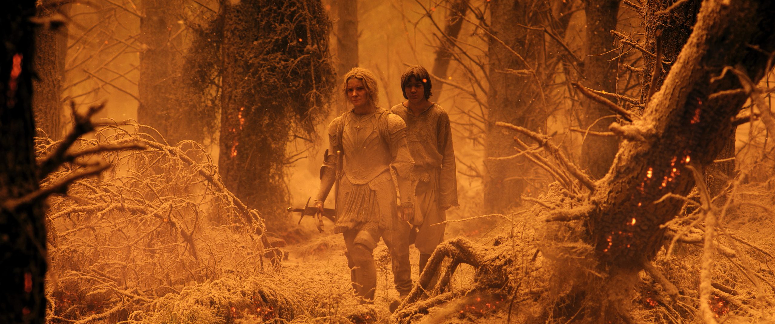 Galadriel (Morfydd Clark) and Theo (Tyroe Muhafidin) trudge forward after Mt. Doom devastates Middle-Earth in The Lord of the Rings: The Rings of Power Season 1 Episode 7 "The Eye" (2022), Amazon Studios