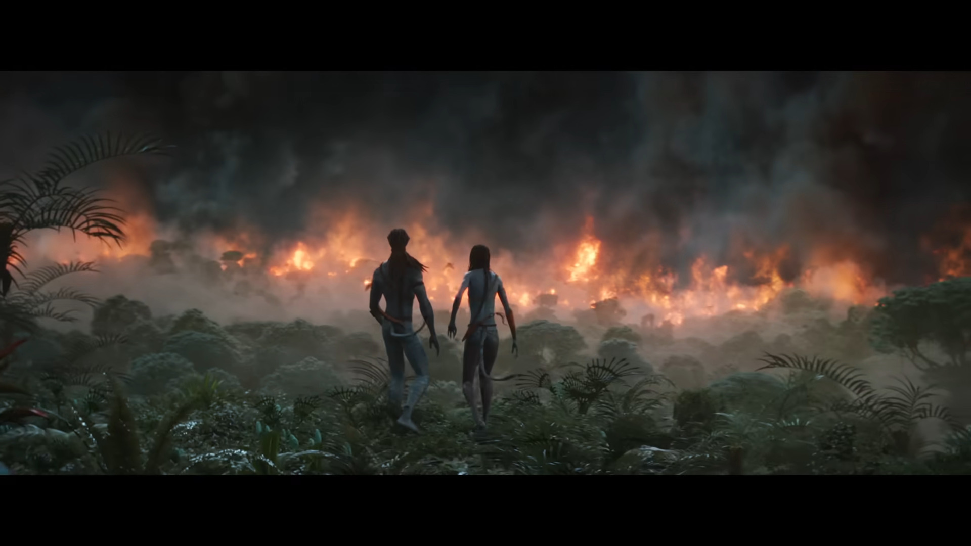 Jake Sully (Sam Worthington) and Neytiri (Zoe Saldaña) look on at the aftermath of an RDA attack in Avatar: The Way of Water (2022), Disney via YouTube