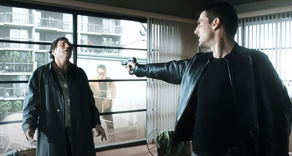 John Anderton (Tom Cruise) points a gun at an enemy in 'Minority Report' (2002), 20th Century Fox