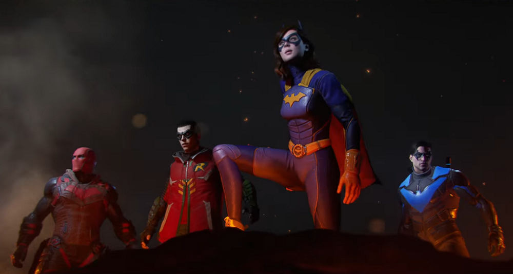 Red Hood, Robin, Batgirl, and Nightwing look out over burning wreckage via Gotham Knights (2022), Warner Bros. Games Montréal