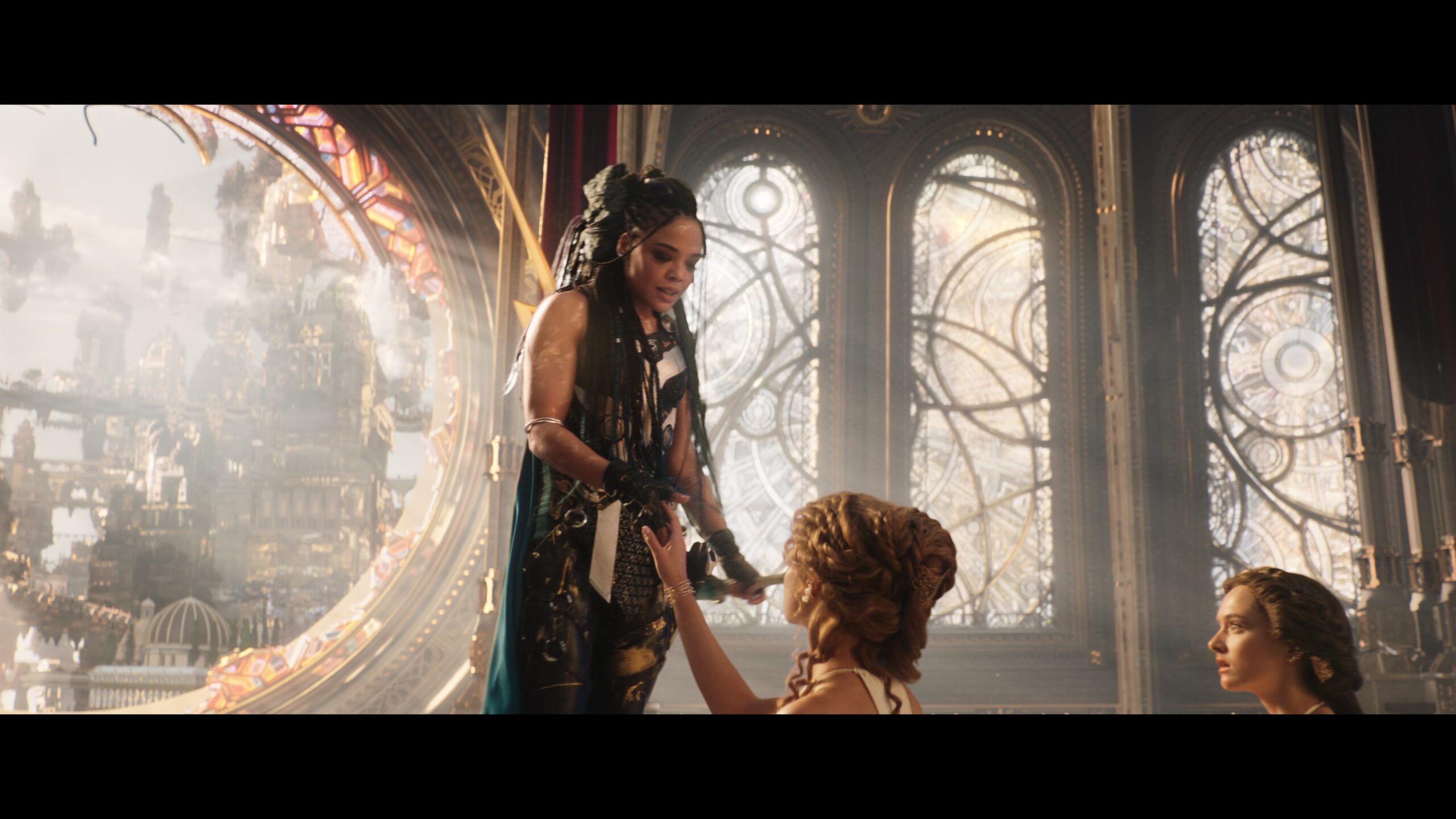 Valkyrie (Tessa Thompson) gives a flirty farewell to one of Zeus' (Russell Crowe) handmaidens in Thor: Love and Thunder (2022), Marvel Entertainment