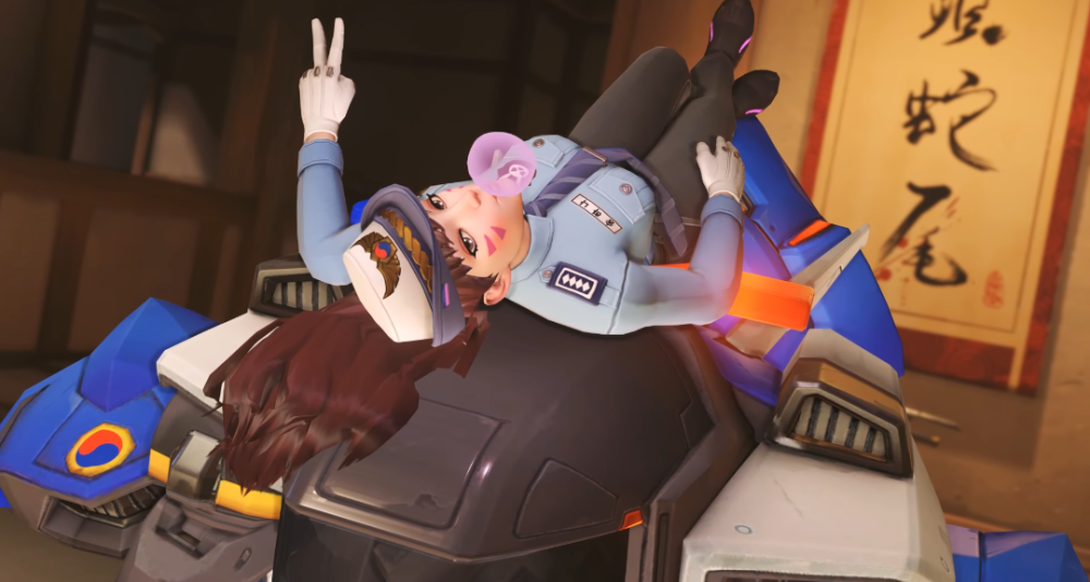 D.Va lazes on top of her mech in her Officer skin, blowing bubblegum and flashing a peace sign via Overwatch (2016), Blizzard Entertainment