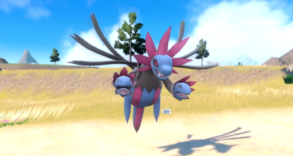 A freshly evolved Hydreigon floats amid a grassy field via Pokémon Scarlet & Violet (2022), Nintendo