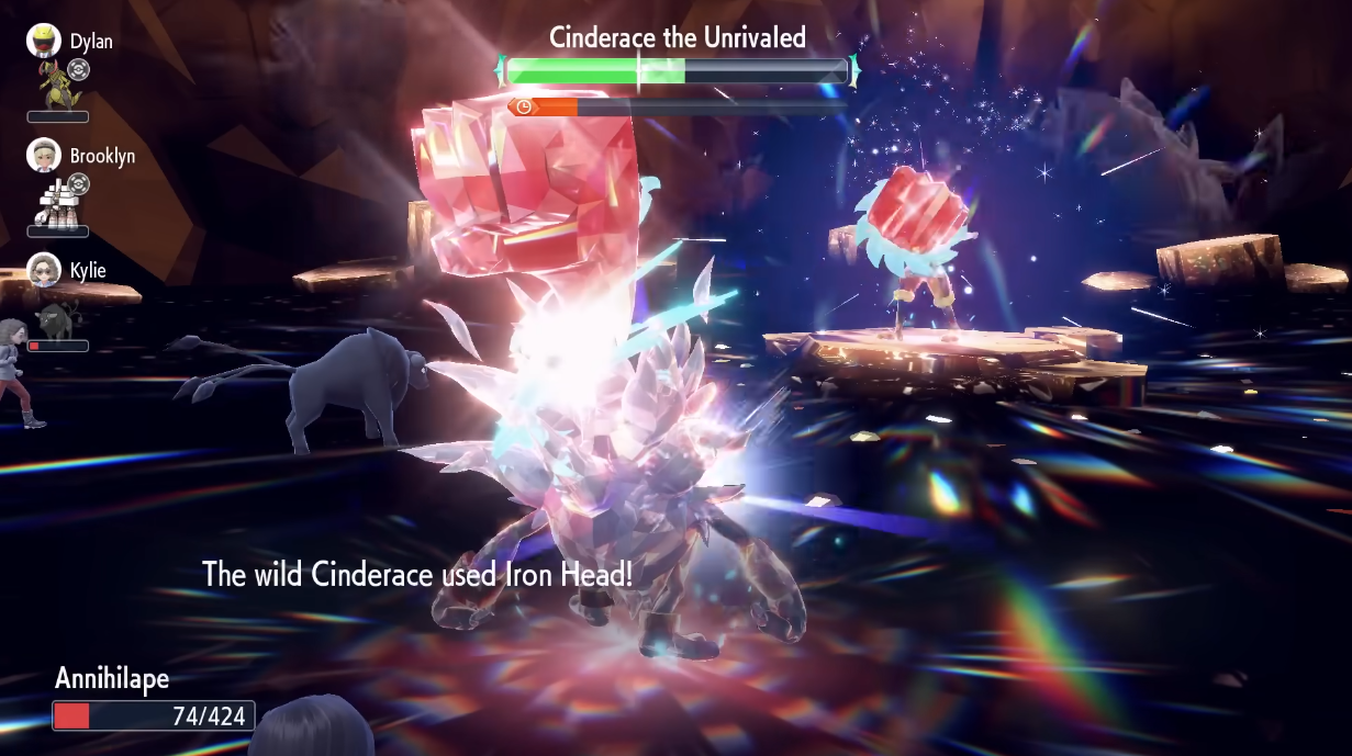 Tera-Fighting Cinderace uses Iron Head against a Tera-Fighting Annihilape in a Tera Raid Battle. A Paldean Tauros is also battling via Pokémon Scarlet & Violet (2022), Nintendo