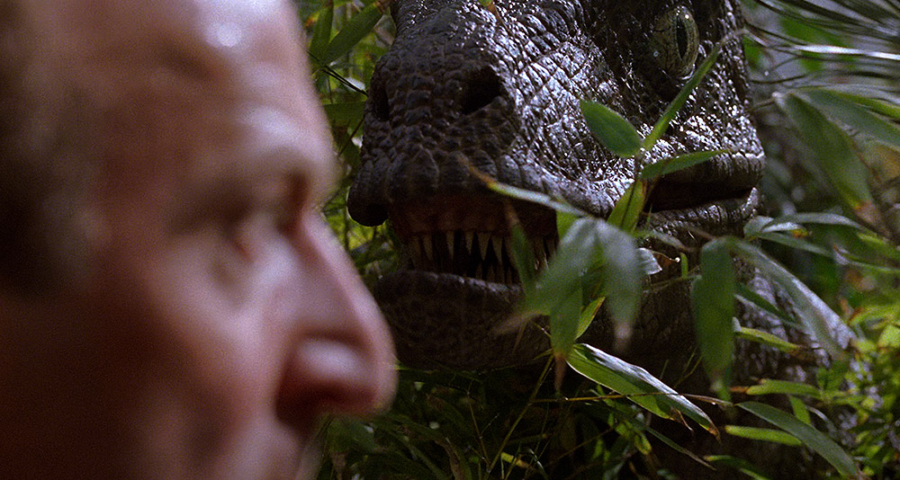A velociraptor sneaks up on Muldoon in 'Jurassic Park' (1993), Universal Pictures