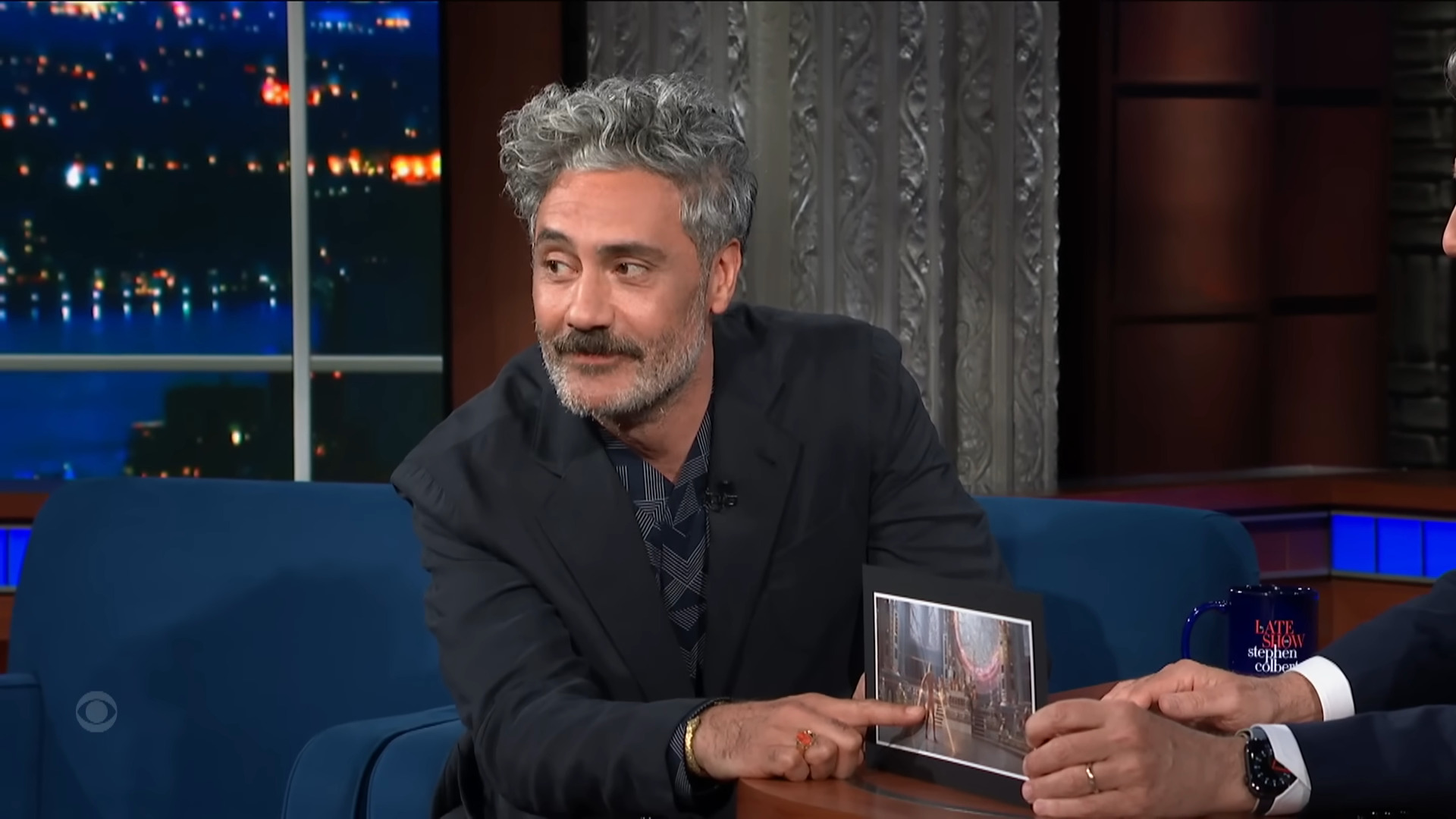 Taika Waititi proudly boasts about featuring a shot of Chris Hemsworth bare body in Thor: Love and Thunder to Stephen Colbert on The Late Show with Stephen Colbert
