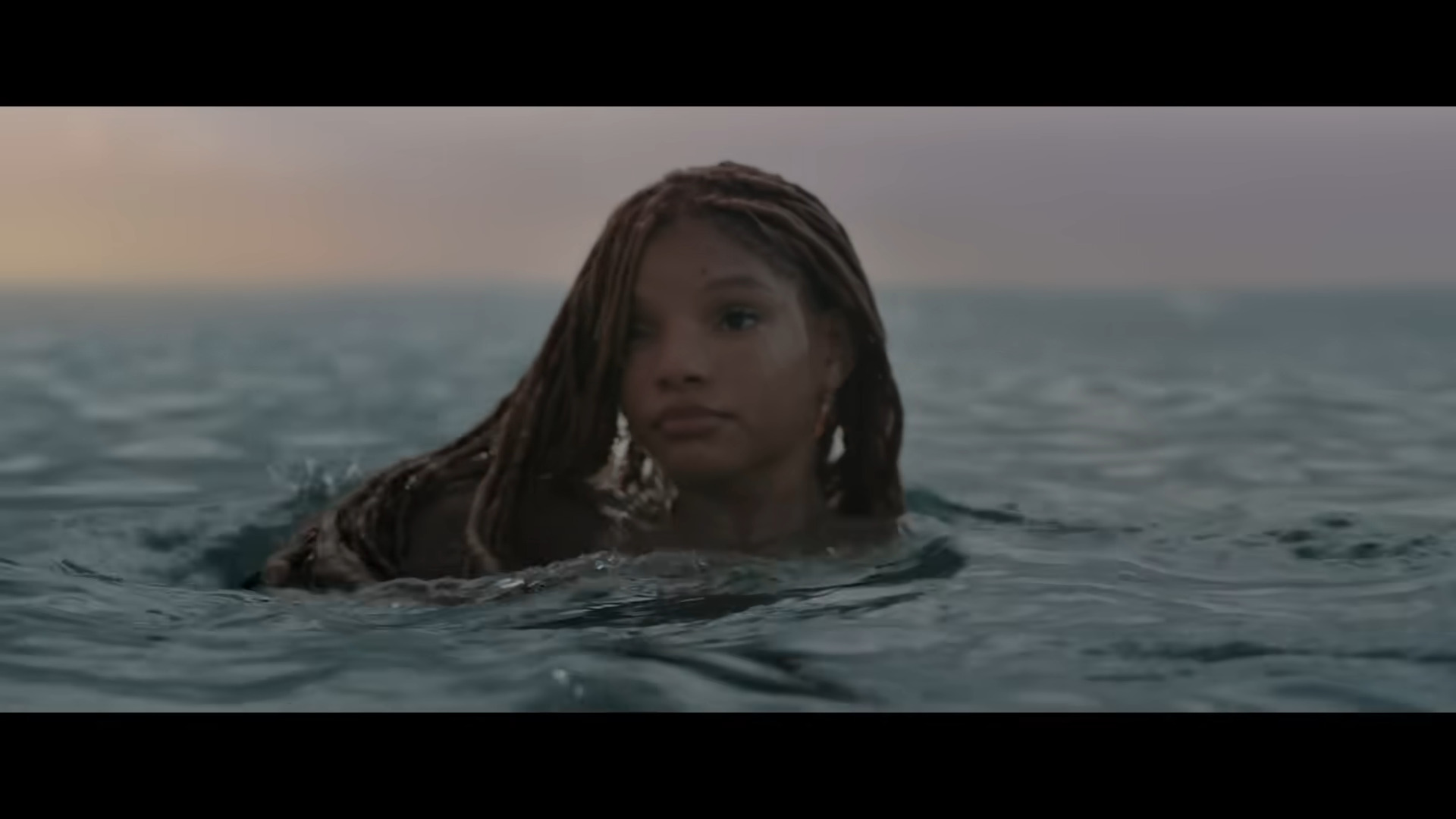 Ariel (Halle Bailey) pops her head above the surface in The Little Mermaid (2023), Disney