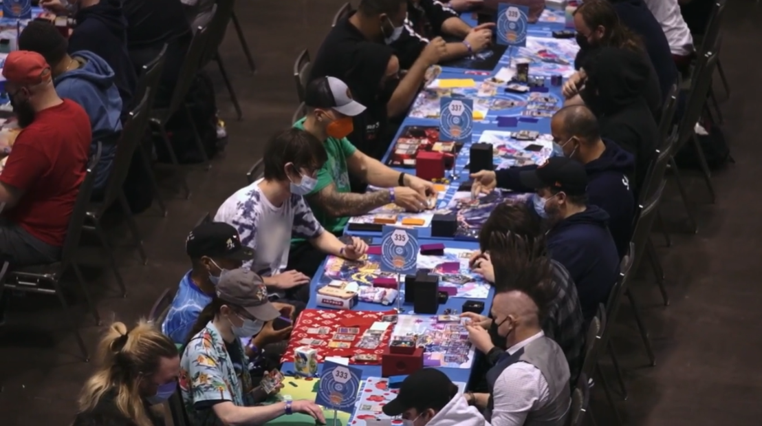 Multiple tables with players playing the Pokémon Trading Card Game wearing face masks via TCG Day 1 | 2023 Pokémon Charlotte Regional Championships, PokemonTCG Twitch