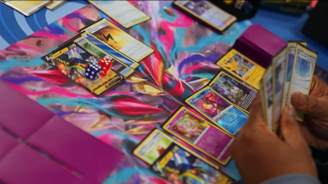 Pokémon Trading Cards sit on a colorful Giratina playmat mid-game via TCG Day 1 | 2023 Pokémon Charlotte Regional Championships, PokemonTCG Twitch