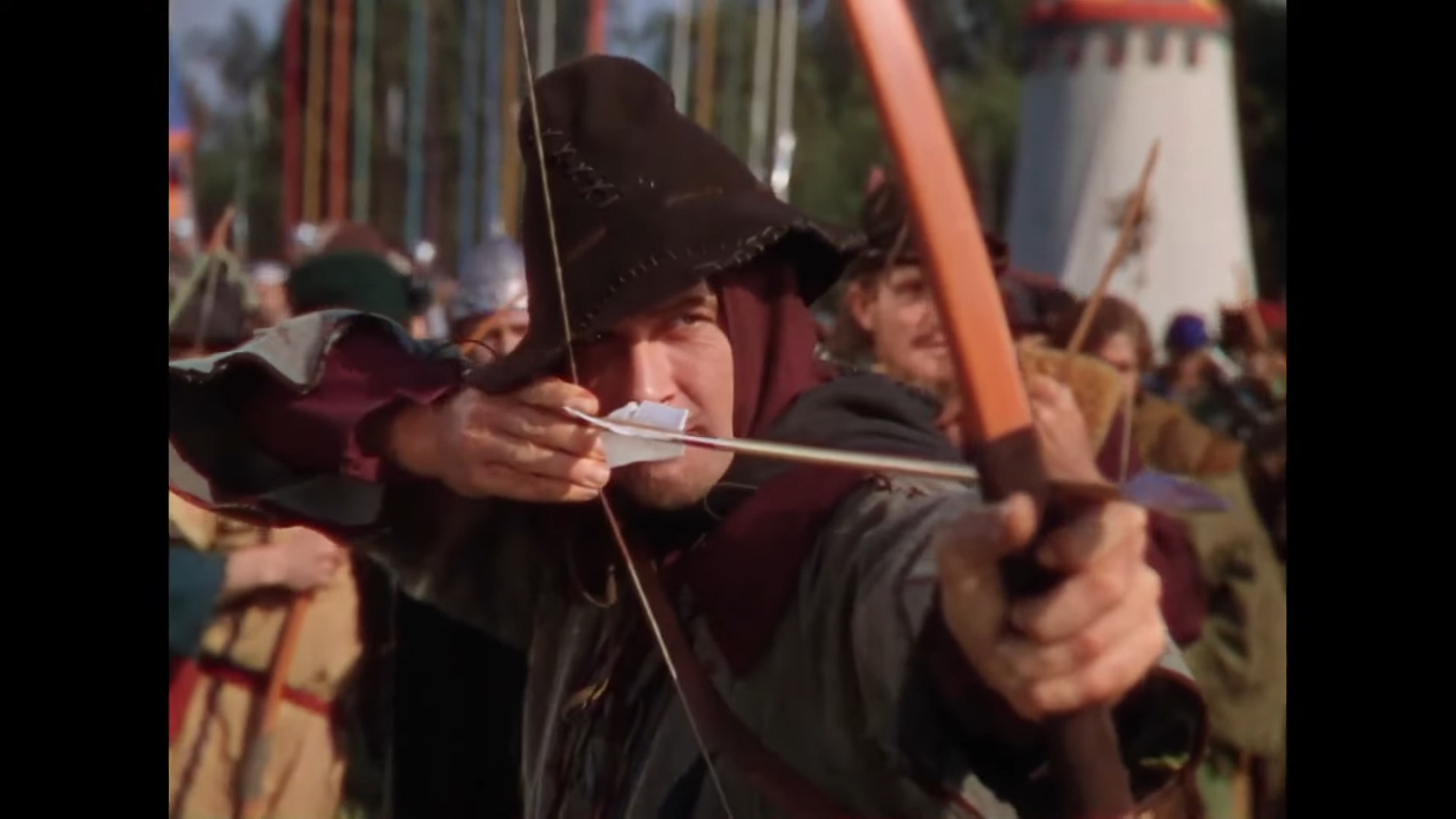 Robin Hood (Errol Flynn) knocks an arrow during King Richard's (Ian Hunter) archery tournament in The Adventures of Robin Hood (1938), Warner Bros. Pictures