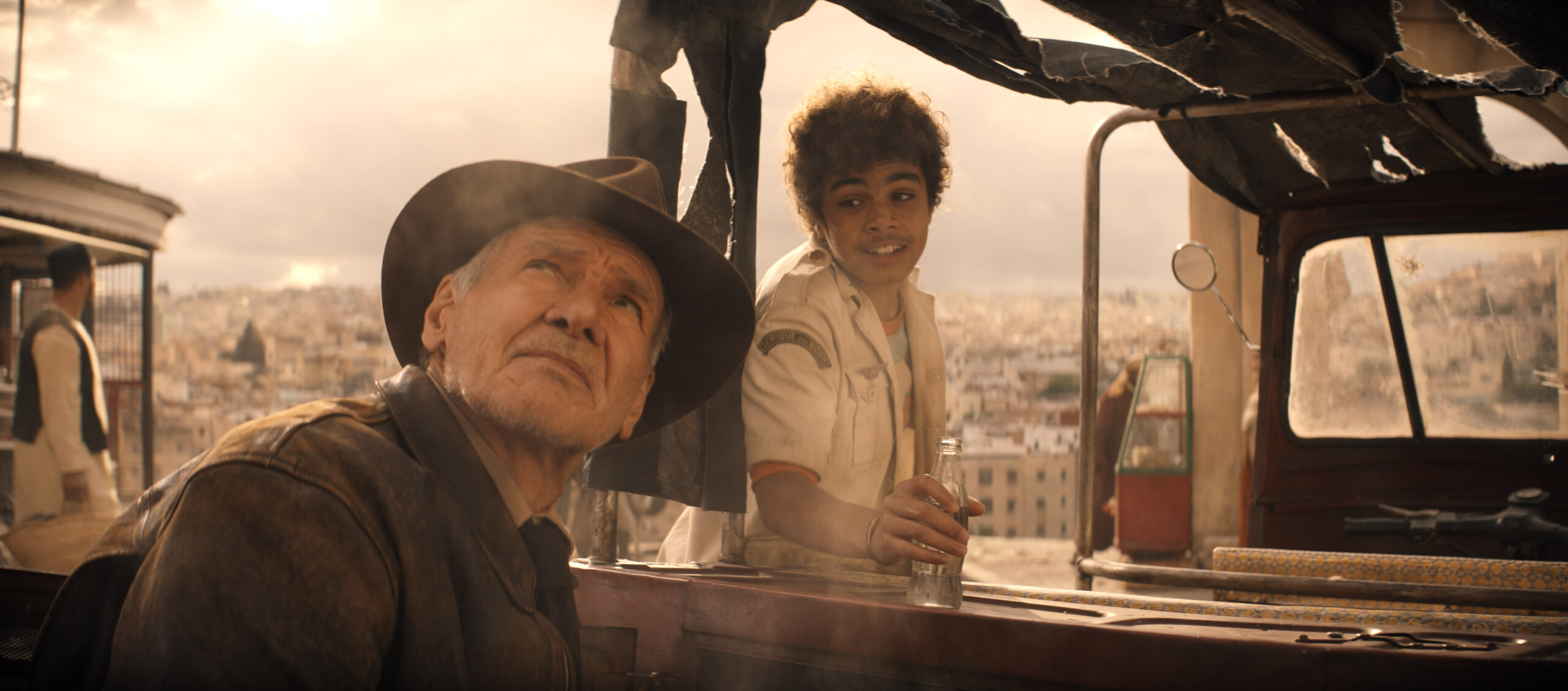 (L-R): Indiana Jones (Harrison Ford) and Teddy (Ethann Isidore) in Lucasfilm's INDIANA JONES AND THE DIAL OF DESTINY. ©2023 Lucasfilm Ltd. & TM. All Rights Reserved.