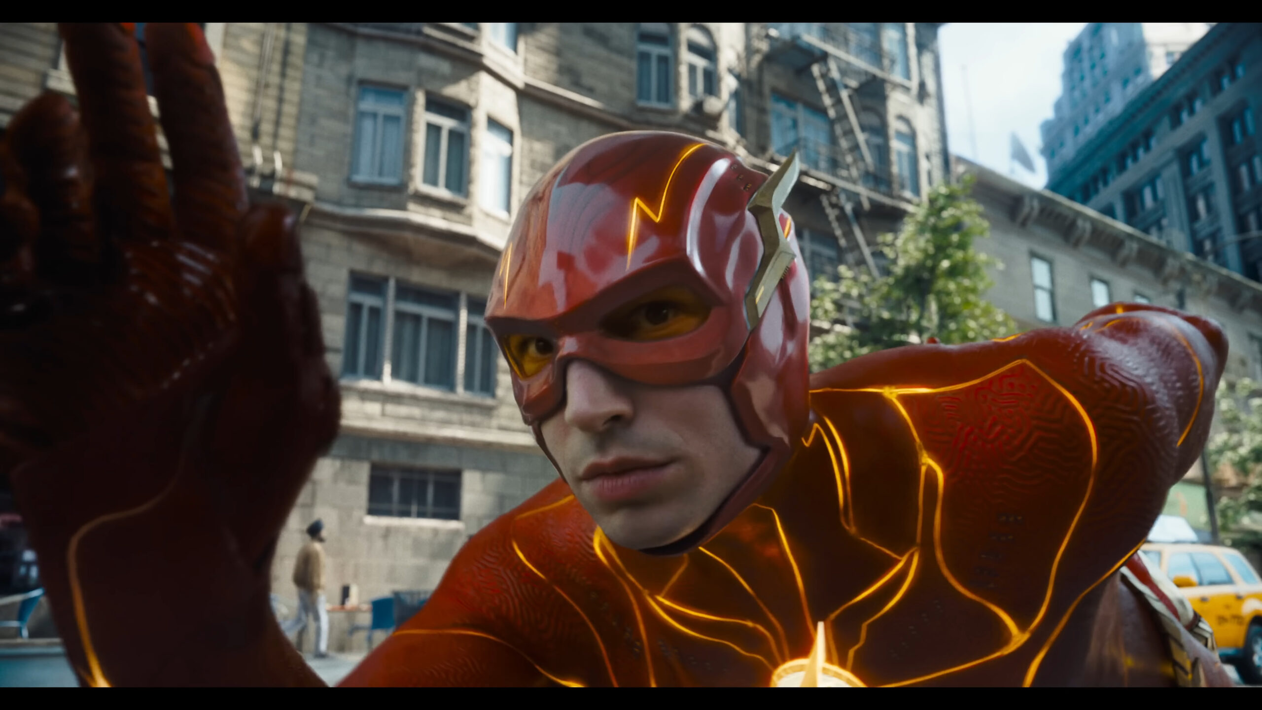 Barry Allen (Ezra Miller) prepares to take off in Batman (Michael Keaton) reveals his cache of Batsuits in The Flash (2023), Warner Bros. Pictures