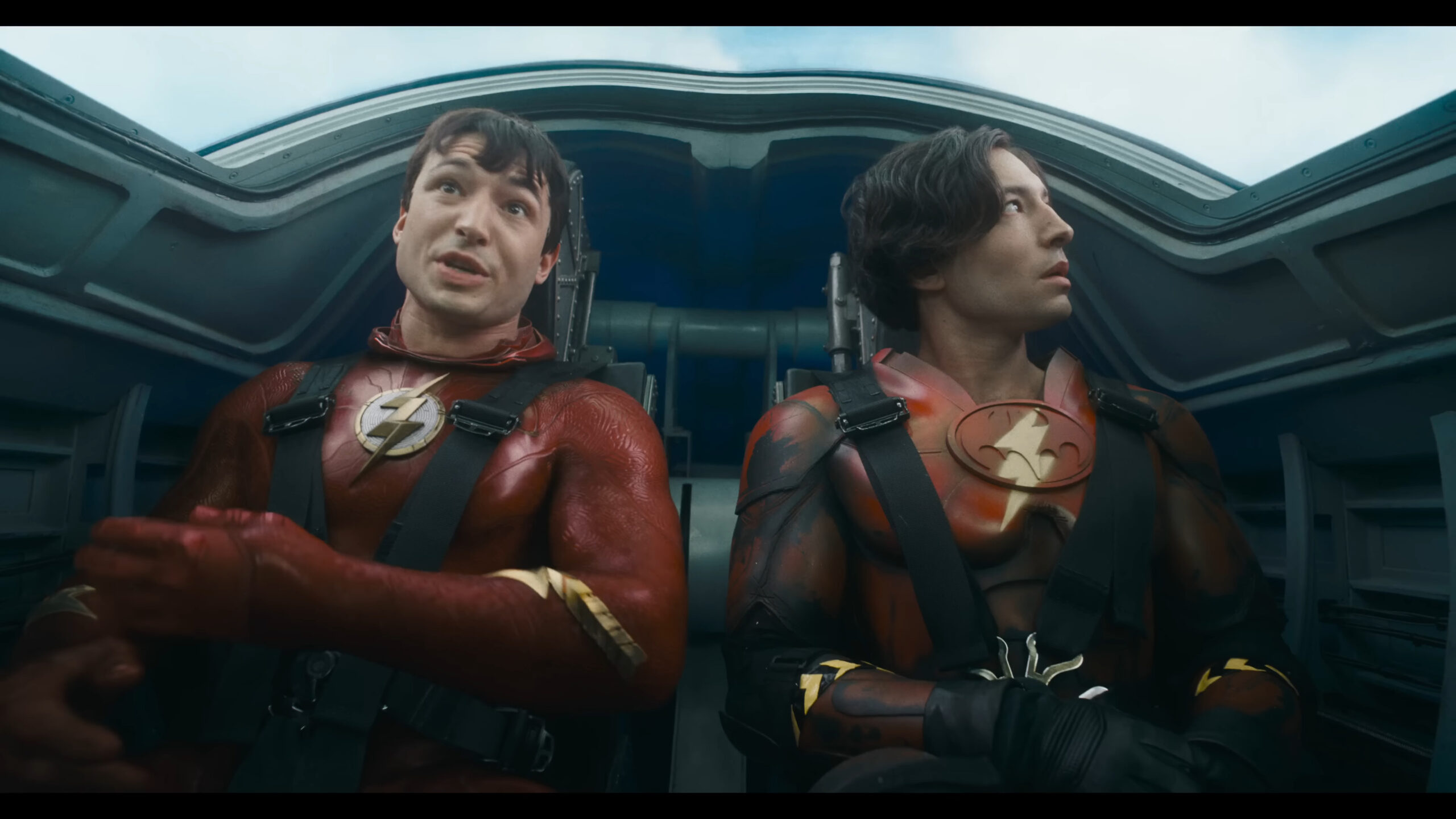 Barry Allen and Barry Allen (Ezra Miller) ride in the Batwing in Batman (Michael Keaton) reveals his cache of Batsuits in The Flash (2023), Warner Bros. Pictures