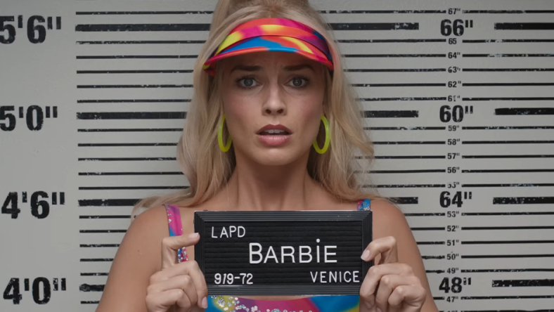 Barbie (Margot Robbie) is arrested in Los Angeles n in Barbie (2023), Warner Bros. Pictures