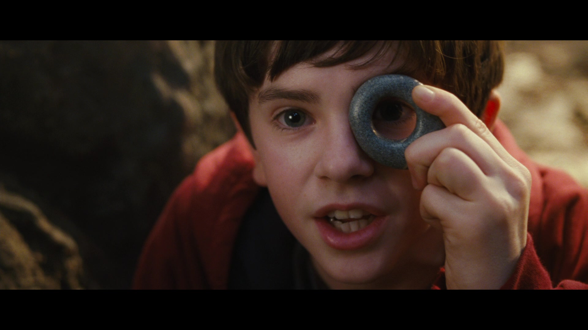 Jared (Freddie Highmore) peers through a holed stone in The Spiderwick Chronicles (2008), Paramount Pictures