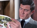 James Bond (George Lazenby) finds some light reading to pass the time in On Her Majesty's Secret Service (1969), United Artists