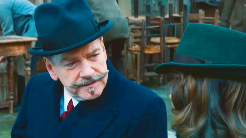 Hercule Poirot (Kenneth Branagh) is intrigued by Ariadne Oliver's (Tina Fey) story in A Haunting in Venice (2023), 20th Century Studios